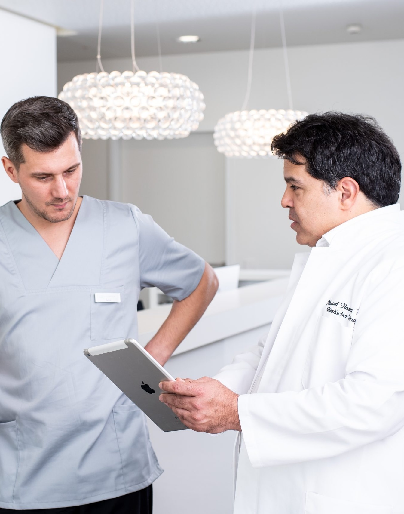 Arzte bespricht mit einem Mitarbeiter weitere Patientenbehandlungen
